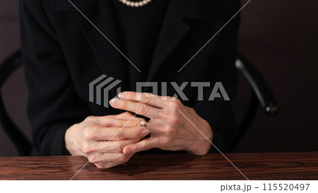 指輪を外す喪服の女性 115520497