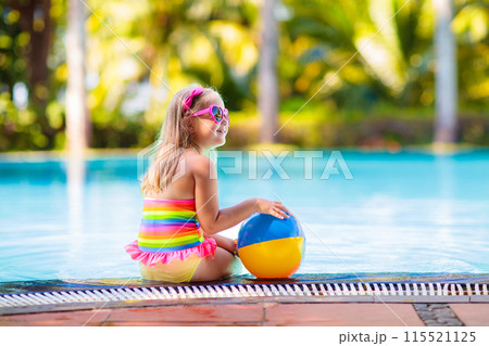 Child in swimming pool with ball. Kids swim. 115521125