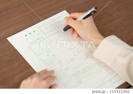 離婚届を書く手元 115521302