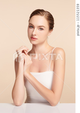 Beautiful young woman with clean fresh skin on beige background, Face care, Facial treatment, Cosmetology, beauty and spa, women portrait. Beautiful young woman with clean fresh skin on beige background, Face care, Facial treatment, Cosmetology, beauty and spa, women portrait. 115521359
