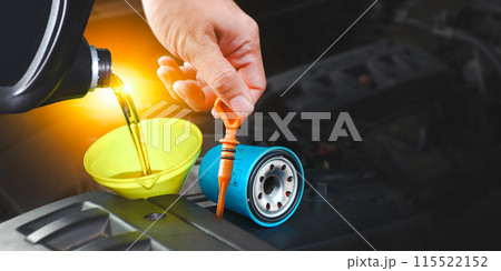 Pouring engine oil into a funnel with spare parts for engine maintenance , copy space Pouring engine oil into a funnel with spare parts for engine maintenance , copy space 115522152