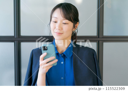 スマホを持つ笑顔の20代の女性 スマホを持つ笑顔の20代の女性 115522309