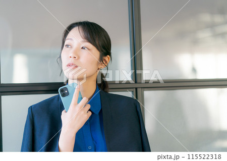 スマホを持ち考える表情の20代の女性 115522318