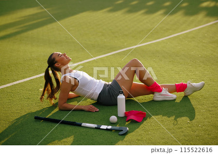 girl hockey player plays field hockey on a sunny day, hockey player drinks water during a break in the match, girl hockey player plays field hockey on a sunny day, hockey player drinks water during a break in the match, 115522616