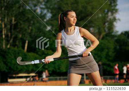 girl hockey player plays field hockey on a sunny day, the hockey player hits the ball with a stick 115522630