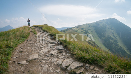 Hiker walking the ridgeline with big mountain behind him, shot in Slovakia, Europe 115522834