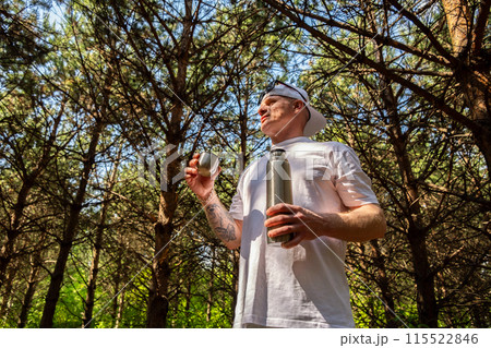 Man drinking tea in the forest. Man drinking tea in the forest. 115522846