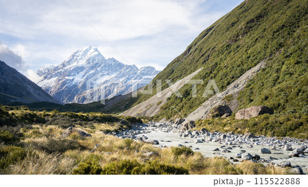 Scenic alpine valley with glacial river flowing through and prominent peak in backdrop, New Zealand 115522888