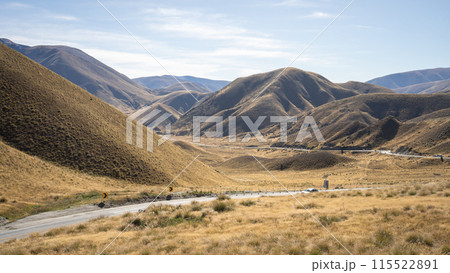 High mountain pass in autumn colors with curvy highway leading through it, New Zealand High mountain pass in autumn colors with curvy highway leading through it, New Zealand 115522891