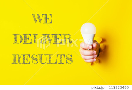 A person holding a light bulb with the words We Deliver Results written below 115523499