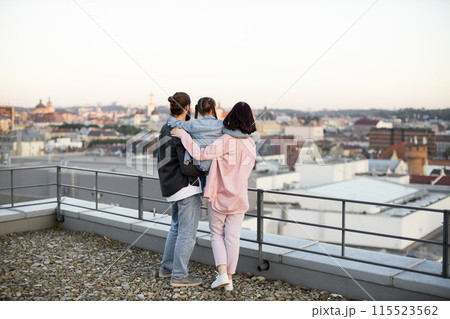 Family enjoying city view from rooftop at sunset 115523562