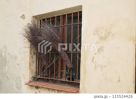 the old window behind the bars. twig broom 115524428