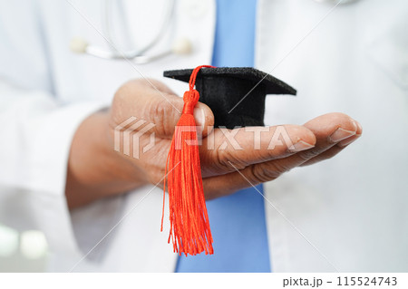 Asian doctor holding graduation gap hat, education medicine. 115524743