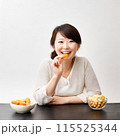 スナック菓子を食べる女性 115525344