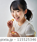 スナック菓子を食べる女性 115525346