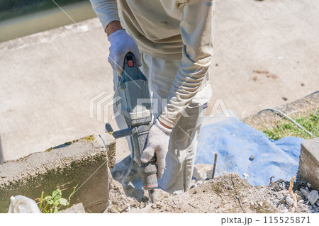 エアーハンマー　エアーチッパー 　エアーチッピングハンマ でコンクリートブロックを崩す作業員エアーハ 115525871