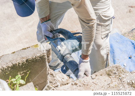 エアーハンマー　エアーチッパー 　エアーチッピングハンマ でコンクリートブロックを崩す作業員エアーハ 115525872