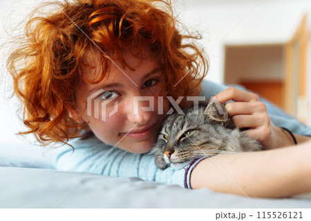 Portrait red-haired curly young woman with beloved fluffy domestic cat Portrait red-haired curly young woman with beloved fluffy domestic cat 115526121