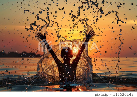 An exuberant person with arms raised creating a large splash in the sea, silhouetted against a radiant golden sunset. Joyful Splash in Sea at Golden Sunset 115526145