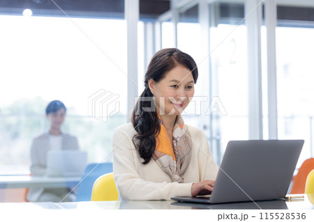 シェアオフィスで仕事をするシニア女性 115528536