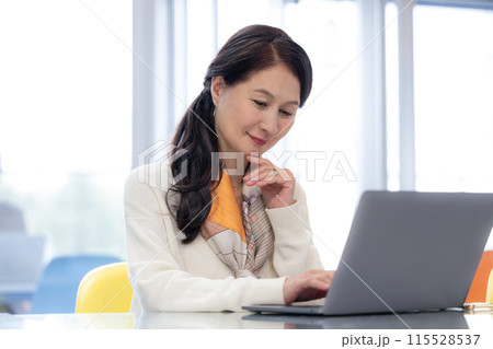 シェアオフィスで仕事をするシニア女性 115528537