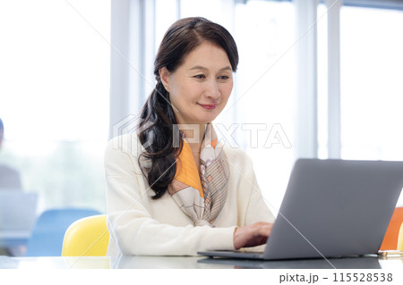 シェアオフィスで仕事をするシニア女性 115528538
