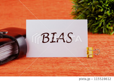 Research and analysis concept. Bias text, word on a white card in front of an orange background with a plant in the background Research and analysis concept. Bias text, word on a white card in front of an orange background with a plant in the background 115528612