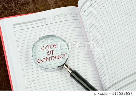 CODE OF CONDUCT words written through a magnifying glass in the notebook of a businessman, manager, teacher CODE OF CONDUCT words written through a magnifying glass in the notebook of a businessman, manager, teacher 115528657