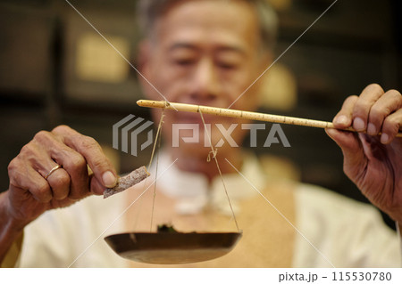 Man Using Old Scale To Measure Herbs Man Using Old Scale To Measure Herbs 115530780