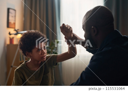 Close up of father and son fighting with dramatic lighting copy space 115531064