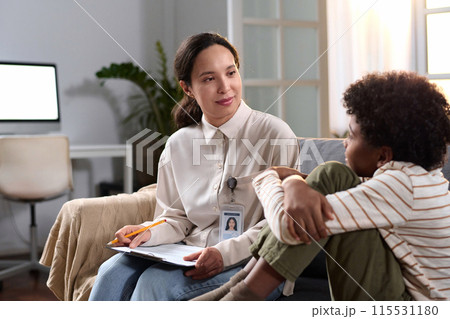 Portrait of female psychologist talking to young child in therapy session for mental health support, copy space Portrait of female psychologist talking to young child in therapy session for mental health support, copy space 115531180