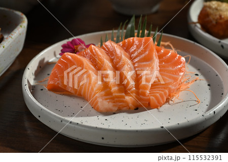 A plate of salmon sashimi on wooden table. Japanese food style concept A plate of salmon sashimi on wooden table. Japanese food style concept 115532391