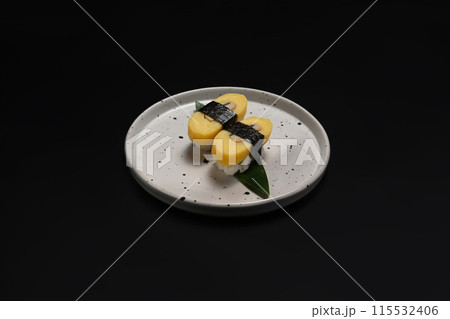 Japanese nigiri Tamago sushi wrapped with nori seaweed on black background. Japanese food concept 115532406