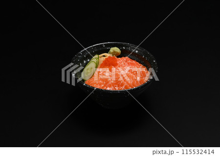 Bowl of salmon Donburi served with wasabi and prickled ginger on black background. Japanese food concept Bowl of salmon Donburi served with wasabi and prickled ginger on black background. Japanese food concept 115532414