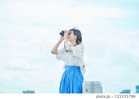 双眼鏡で遠くの景色を見る若い女性 双眼鏡で遠くの景色を見る若い女性 115535796
