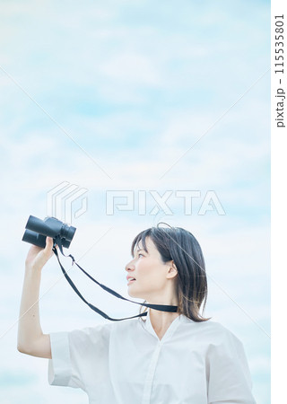 双眼鏡で遠くの景色を見る若い女性 双眼鏡で遠くの景色を見る若い女性 115535801