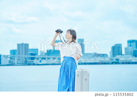 双眼鏡で遠くの景色を見る若い女性 115535802