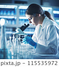 Young scientist conduct research investigations in a medical laboratory, a researcher in the foreground is using a microscope 115535972