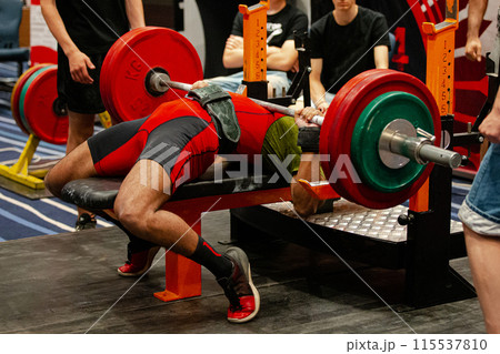 indian athlete perform bench press surrounded by assistants at powerlifting competition indian athlete perform bench press surrounded by assistants at powerlifting competition 115537810