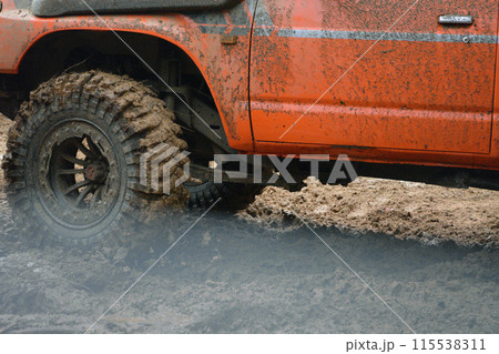 a red SUV in the mud accelerates to overcome obstacles. Off-road competition for SUVs. 115538311