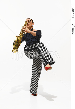 Dynamic image of elegant woman, stylish saxophonist playing saxophone with soul and energy isolated on white background 115538508