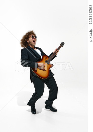 Young emotional man, musician with curly hair plays an electric guitar isolated on white background 115538568