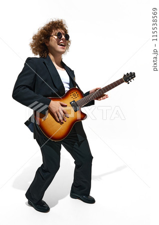 Young emotional man, musician with curly hair plays an electric guitar isolated on white background Young emotional man, musician with curly hair plays an electric guitar isolated on white background 115538569