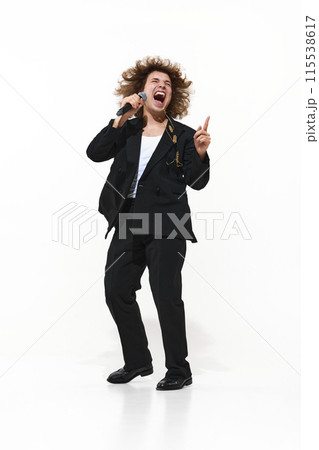 Live Performance. Full-length portrait of energetic and emotional man, musician in black suit singing isolated on white background Live Performance. Full-length portrait of energetic and emotional man, musician in black suit singing isolated on white background 115538617