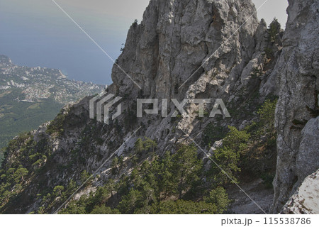 Mount Ai-petri.View from above. View from the mountain, below is a valley flowing into the Black Sea.You can also see many trees growing right on the rock. Mount Ai-petri.View from above. View from the mountain, below is a valley flowing into the Black Sea.You can also see many trees growing right on the rock. 115538786