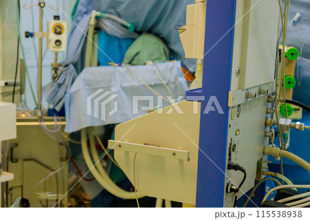 An operating room is being used by physician to perform surgery on patient An operating room is being used by physician to perform surgery on patient 115538938