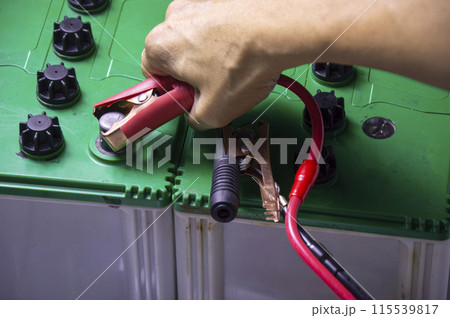 Top view, mechanic working with battery tweezers Top view, mechanic working with battery tweezers 115539817
