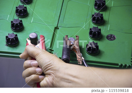 mechanic working with battery tweezers 115539818