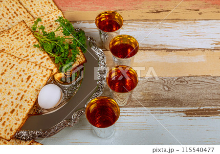 During Pesach, families gather to commemorate liberation of Israelites with red kosher wine unleavened bread matzo 115540477
