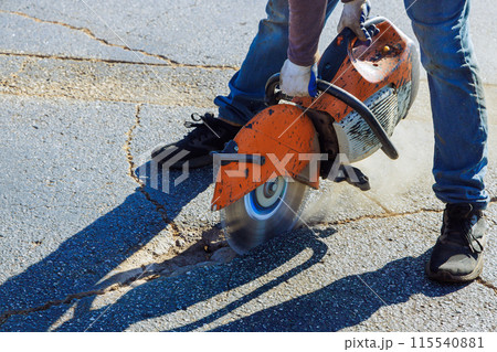 An asphalt has been damaged by use of diamond blade saw in parking lot An asphalt has been damaged by use of diamond blade saw in parking lot 115540881